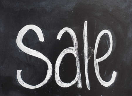 Sale sign written on blackboard in whiteの写真素材