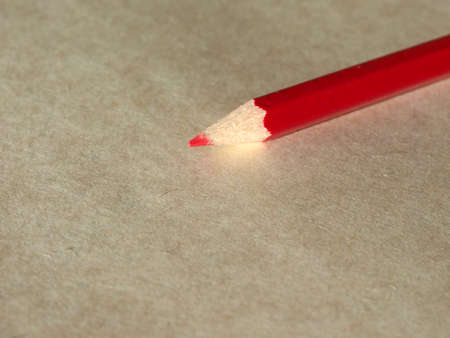 A red pencil over brown paper backgroundの写真素材