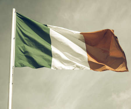 Vintage looking Irish flag over a blue sky backgroundの写真素材