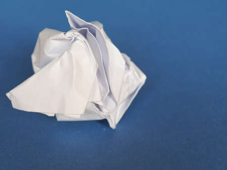 white crumpled paper sheet over blue paper background with copy spaceの写真素材