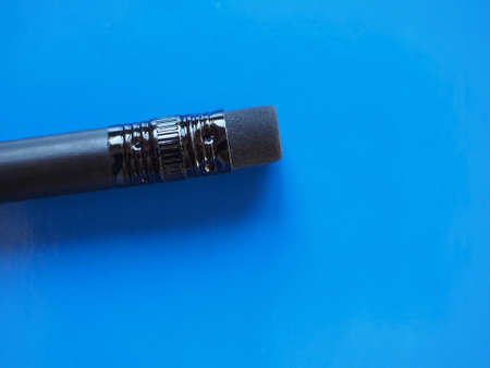 black pencil rubber over blue paper texture background with copy spaceの写真素材