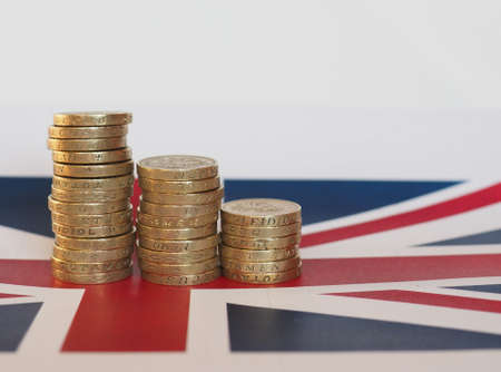 Pound coins money (GBP), currency of United Kingdom, over the Union Jack