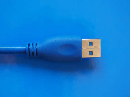 USB plug for computer over blue backgroundの写真素材
