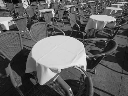 Many tables and chairs at an outdoor alfresco bar in black and white Many tables and chairs at an outdoor alfresco bar in black and white