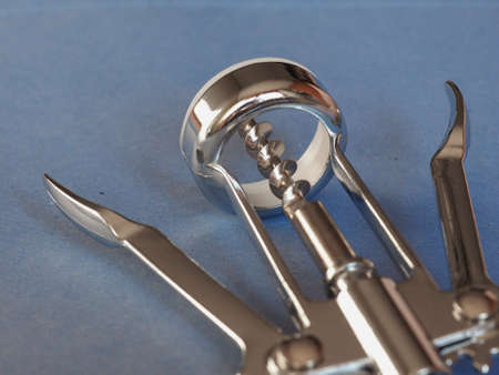 corkscrew (bottle screw) with bottle opener over blue backgroundの写真素材