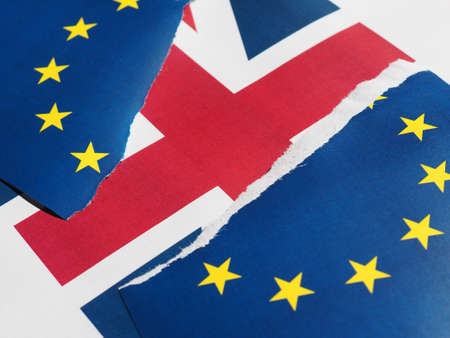 Torn European Union flag over Union Jack United Kingdom flag, symbol of Brexitの写真素材