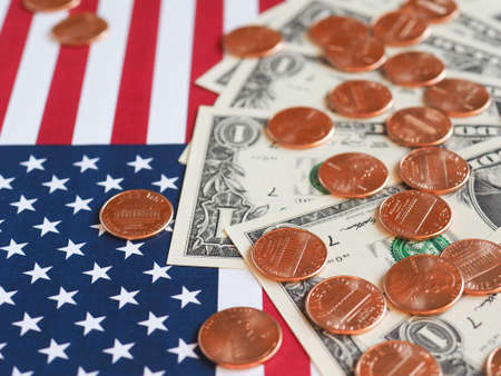 One Dollar banknotes and One Cent coins (USD) currency money over the flag of the United Statesの写真素材