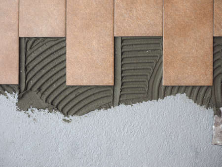 laying floor tiles in a building siteの写真素材