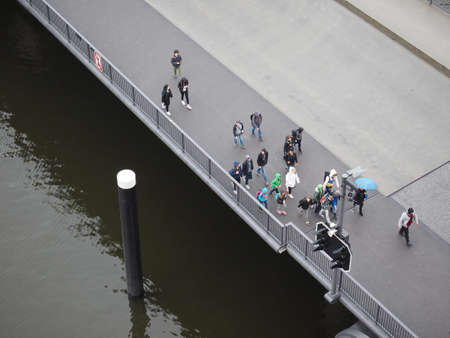 HAMBURG, GERMANY - CIRCA MAY 2017: A crowd of people crossing Am Kaiserkai bridge
