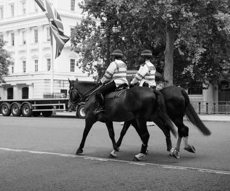 LONDON, UK - CIRCA JUNE 2017: Mounted metropolitan police officers patrol on horseback on the Strand in black and whiteのeditorial素材