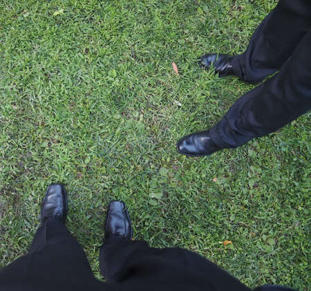 men dressed in black on the grass in a meadow with copy space