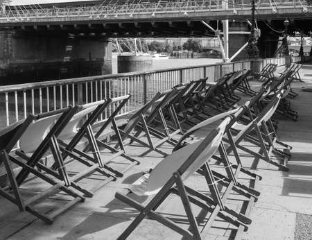 LONDON, UK - CIRCA JUNE 2017: Deckchairs on the bank of River Thames in black and whiteのeditorial素材