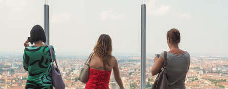 Women looking from panoramic viewpoint on top of skyscraperの写真素材