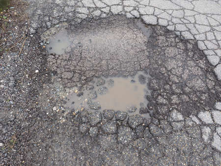 Pothole in a street caused by failure primarily in asphalt pavementの写真素材