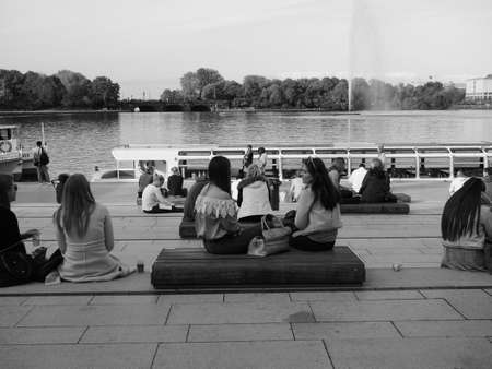 HAMBURG, GERMANY - CIRCA MAY 2017: People on Binnenalster (meaning Inner Alster lake) bank in black...