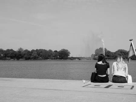HAMBURG, GERMANY - CIRCA MAY 2017: People on Binnenalster (meaning Inner Alster lake) bank in black...