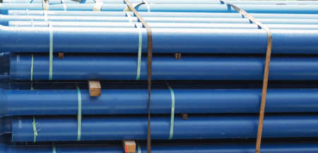 large blue pipes being transported on a truck