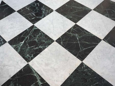 chequered white green and black stone floor useful as a backgroundの写真素材