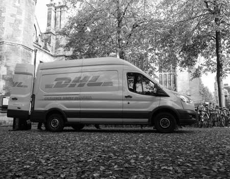 CAMBRIDGE, UK - CIRCA OCTOBER 2018: DHL courier van in black and white