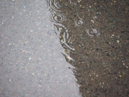 Water circles in a puddle of rain water useful as a background