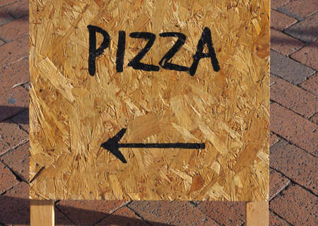 Pizza sign with direction arrow on wooden board
