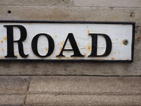 black over white road sign on a stone wallの写真素材