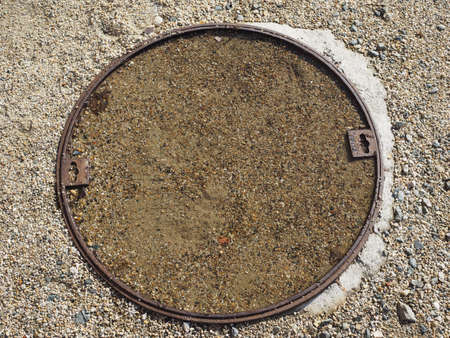 brown pebble texture with manhole useful as a backgroundの写真素材