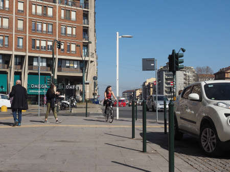 TURIN, ITALY - CIRCA FEBRUARY 2019: Pedestrians and woman on bike in the city centreのeditorial素材