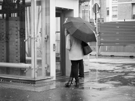 TURIN, ITALY - CIRCA NOVEMBER 2018: Woman with umbrella at Lingotto underground station entrance in black and whiteのeditorial素材