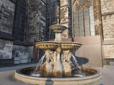 Petrusbrunnen (meaning St Peter fountain) by the Koelner Dom Hohe Domkirche Sankt Petrus (meaning St Peter Cathedral) gothic church in Koeln, Germanyの写真素材