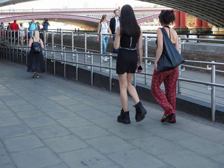 LONDON, UK - CIRCA SEPTEMBER 2019: People walking down the sidewalk on the bank of River Thames