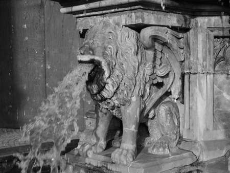 Petrusbrunnen (meaning St Peter fountain) by the Koelner Dom Hohe Domkirche Sankt Petrus (meaning St Peter Cathedral) gothic church in Koeln, Germany in black and whiteの写真素材