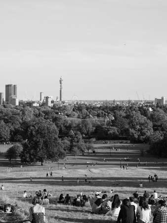 LONDON, UK - CIRCA SEPTEMBER 2019: People at Primrose Hill north of Regent's Park looking at London skyline at sunset in black and whiteのeditorial素材