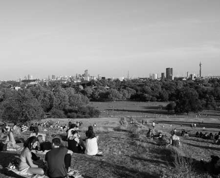 LONDON, UK - CIRCA SEPTEMBER 2019: People at Primrose Hill north of Regent's Park looking at London skyline at sunset in black and whiteのeditorial素材