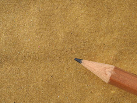 wooden pencil on blank brown paper with copy spaceの写真素材