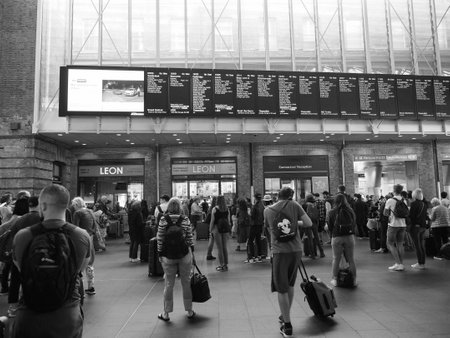 LONDON, UK - CIRCA SEPTEMBER 2019: Travellers at King's Cross railway station in black and white