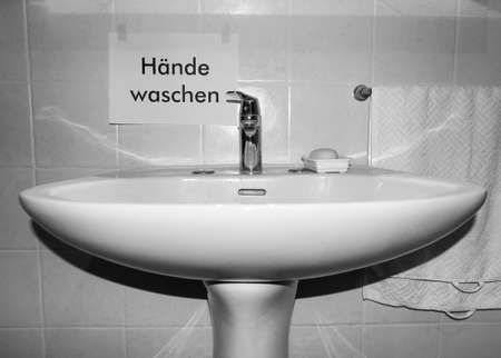 Haende waschen (translation: wash your hands) sign near bathroom basinの写真素材