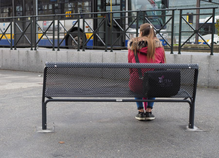TURIN, ITALY - CIRCA NOVEMBER 2019: woman waiting for transport at Turin Porta Susa bus stationのeditorial素材