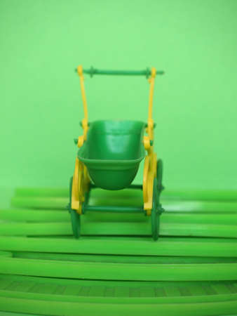 empty green plastic toy baby pushchair (aka stroller)の写真素材