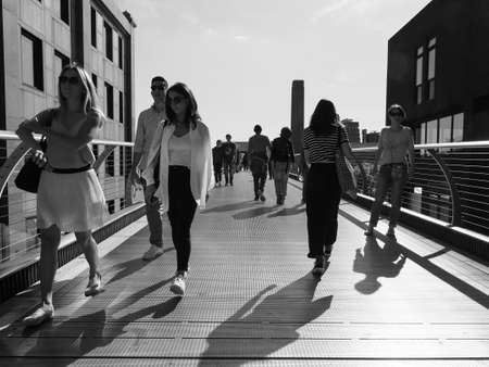 LONDON, UK - CIRCA SEPTEMBER 2019: People crossing Millennium Bridge over River Thames linking the City of London with the South Bank between St Paul Cathedral and Tate Modern art gallery in black and whiteのeditorial素材