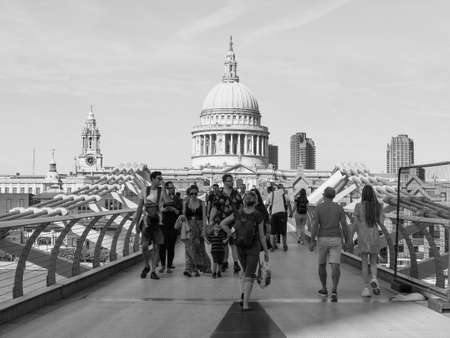 LONDON, UK - CIRCA SEPTEMBER 2019: People crossing Millennium Bridge over River Thames linking the City of London with the South Bank between St Paul Cathedral and Tate Modern art gallery in black and whiteのeditorial素材