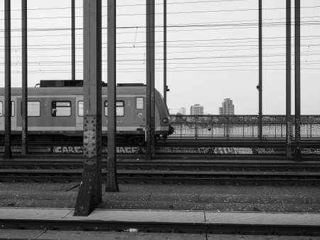 KOELN, GERMANY - CIRCA AUGUST 2019: Hohenzollernbruecke (meaning Hohenzollern Bridge) crossing the river Rhein in black and whiteのeditorial素材