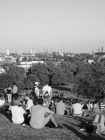 LONDON, UK - CIRCA SEPTEMBER 2019: People at Primrose Hill north of Regent's Park looking at London skyline at sunset in black and whiteのeditorial素材