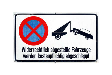 German traffic sign isolated over white background. Widerrechtlich abgestellte Fahrzeuge werden kostenpflichtig abgeschleppt (translation: Vehicles illegally parked will be towed away for a fee)の写真素材