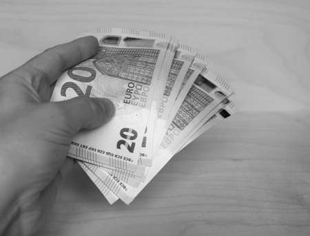 Hand holding Euro banknotes money (EUR), currency of European Union in black and whiteの写真素材