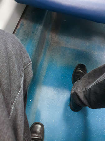Unrecognisable man with smart shoes on a regional train