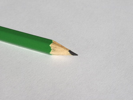 green pencil on blank paper sheet with copy spaceの写真素材
