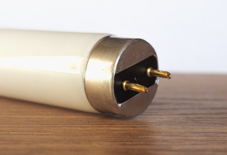 fluorescent tube light bulb over wooden desktop