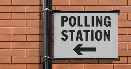 Polling station sign for UK elections over red bricks wallの写真素材