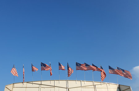 many american flags of the united states of america over blue skyの写真素材